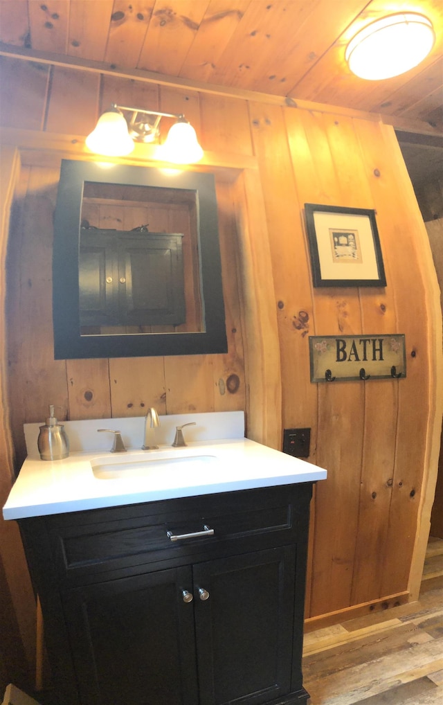 bathroom with wood finished floors, vanity, wood walls, and wood ceiling