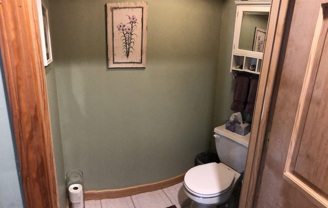 bathroom featuring baseboards, toilet, and tile patterned flooring