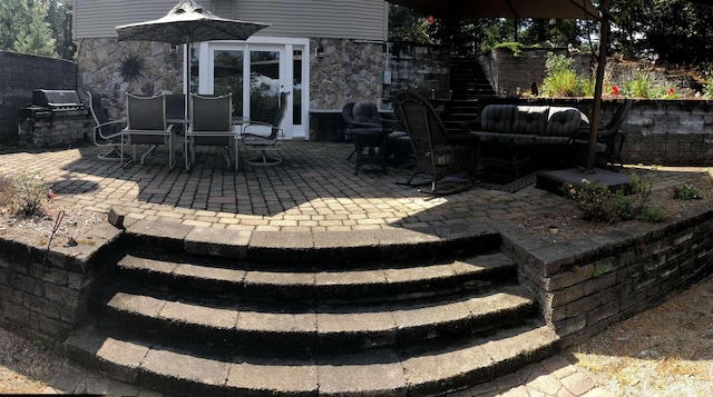 view of patio with grilling area, outdoor dining space, and stairs
