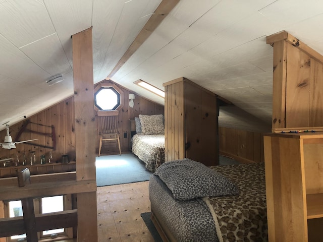 bedroom with lofted ceiling, wood walls, and wood finished floors
