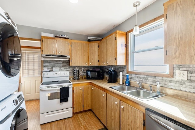 kitchen with stacked washer and clothes dryer, ventilation hood, electric stove, stainless steel dishwasher, and a sink
