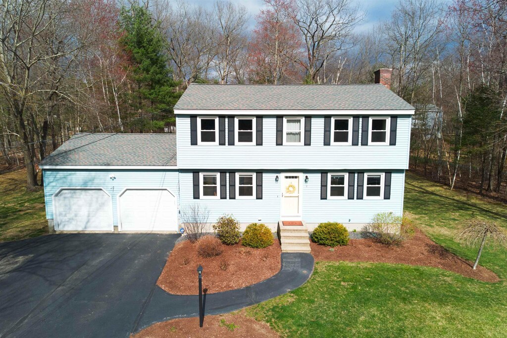 4 Williams Dr, Hudson, NH 03051 - colonial home featuring roof with shingles, driveway, a chimney, an attached garage, and a front yard