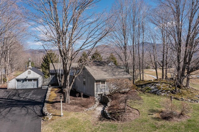 3360 Dorset W Rd, Dorset, VT 05251 - view of home's exterior featuring aphalt driveway, an outdoor structure, a mountain view, and a detached garage