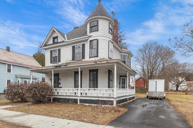 victorian house featuring driveway and covered porch