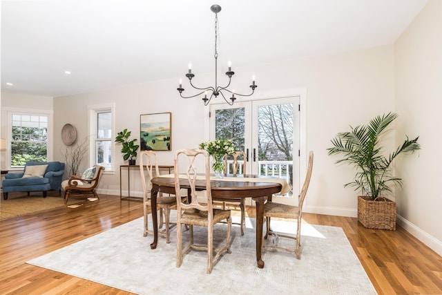 dining room with a chandelier, light wood finished floors, baseboards, and recessed lighting