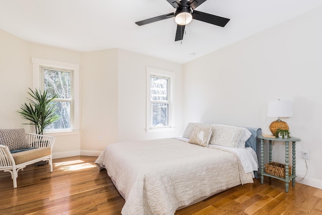 bedroom featuring baseboards, a ceiling fan, and wood finished floors