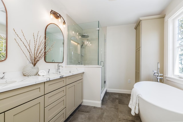 full bathroom featuring a shower stall, double vanity, a sink, baseboards, and a freestanding tub