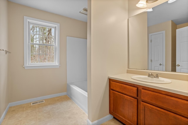 bathroom featuring a bath, baseboards, visible vents, and vanity