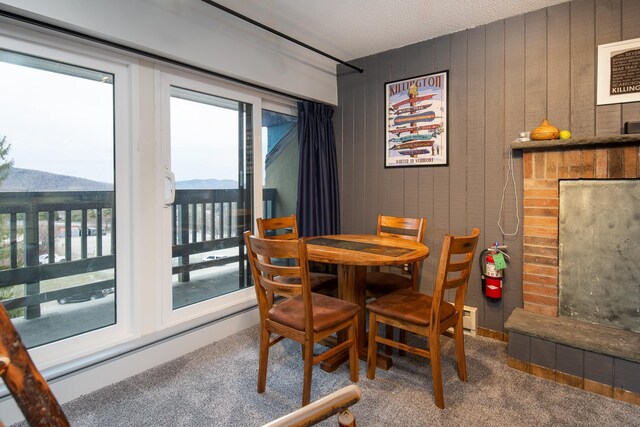135 E Mountain Rd Unit 1F7, Killington, VT 05751 - carpeted dining room featuring a fireplace, a mountain view, and a healthy amount of sunlight