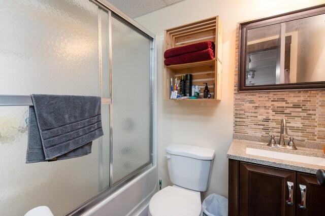 135 E Mountain Rd Unit 1F7, Killington, VT 05751 - bathroom with decorative backsplash, vanity, bath / shower combo with glass door, and toilet