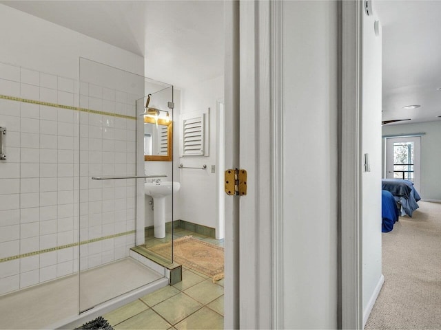 bathroom with connected bathroom, tile patterned flooring, and tiled shower