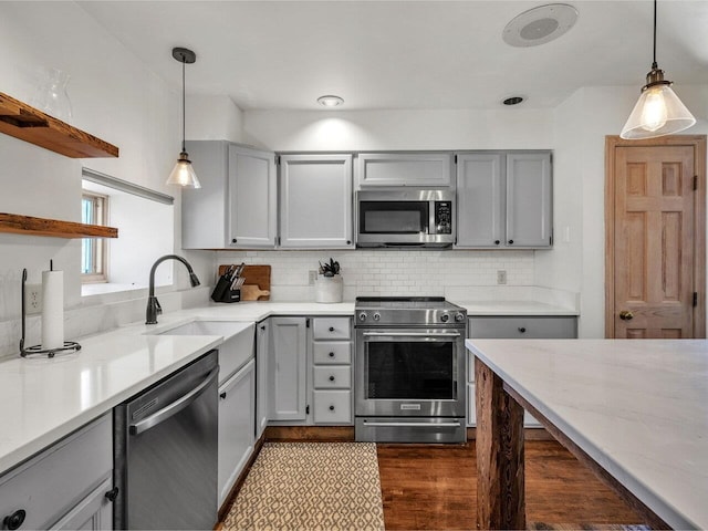 kitchen featuring open shelves, tasteful backsplash, gray cabinets, and stainless steel appliances