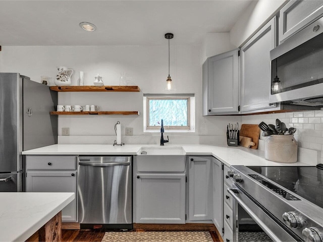 kitchen featuring gray cabinets, tasteful backsplash, stainless steel appliances, and a sink