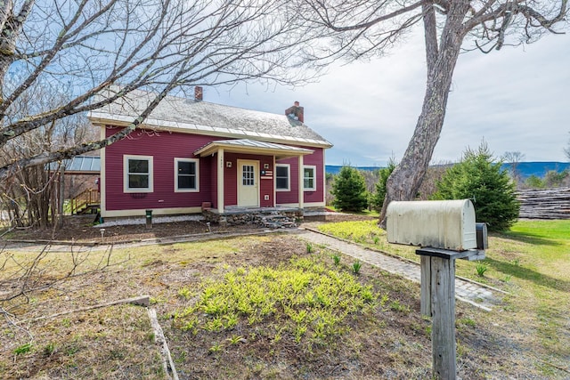 bungalow-style home with a chimney and fence