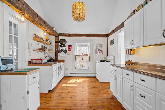 kitchen featuring a baseboard heating unit, a sink, dark countertops, vaulted ceiling, and open shelves