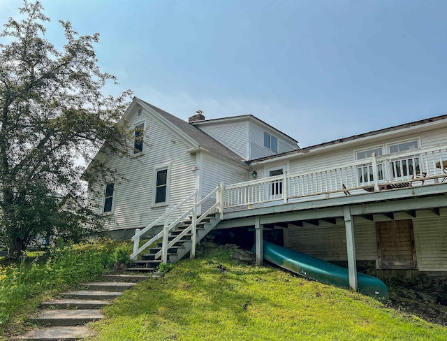 165 N Main St, Rochester, VT 05767 - rear view of house featuring stairway, a deck, a chimney, and a lawn