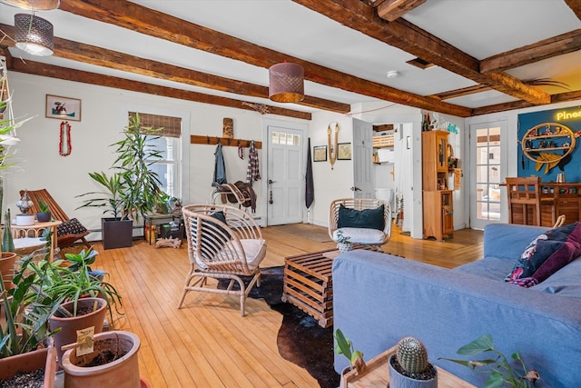 living area with beam ceiling and light wood-style floors