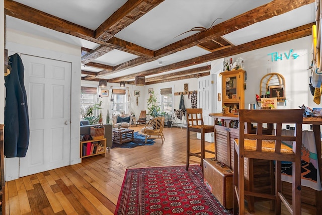dining area featuring hardwood / wood-style flooring, coffered ceiling, a healthy amount of sunlight, and beam ceiling