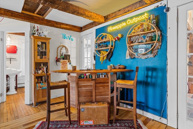 bar featuring beamed ceiling and hardwood / wood-style flooring