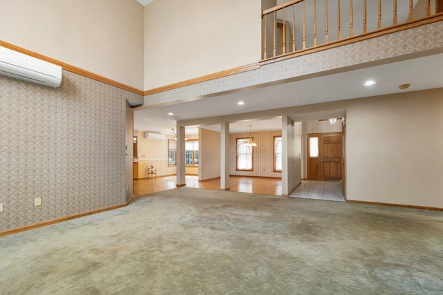 11 Harvest Run, Gilford, NH 03249 - unfurnished living room featuring wallpapered walls, baseboards, a wall mounted AC, an AC wall unit, and carpet