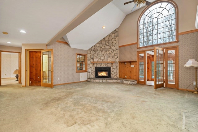 11 Harvest Run, Gilford, NH 03249 - unfurnished living room featuring ceiling fan, high vaulted ceiling, a stone fireplace, carpet, and wallpapered walls