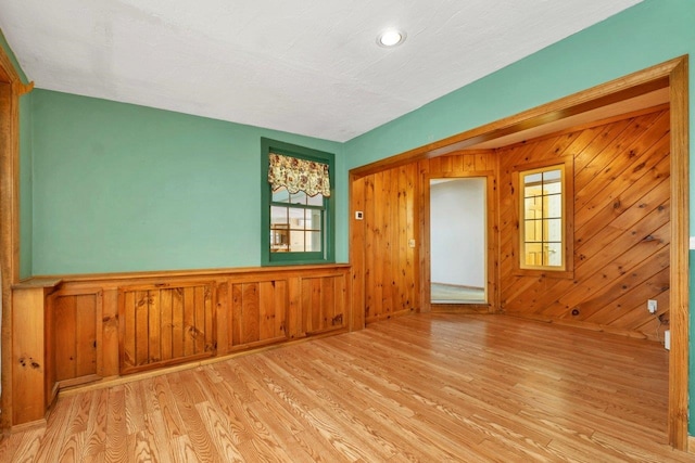11 Harvest Run, Gilford, NH 03249 - unfurnished room with a wainscoted wall, wood finished floors, a wealth of natural light, and wooden walls