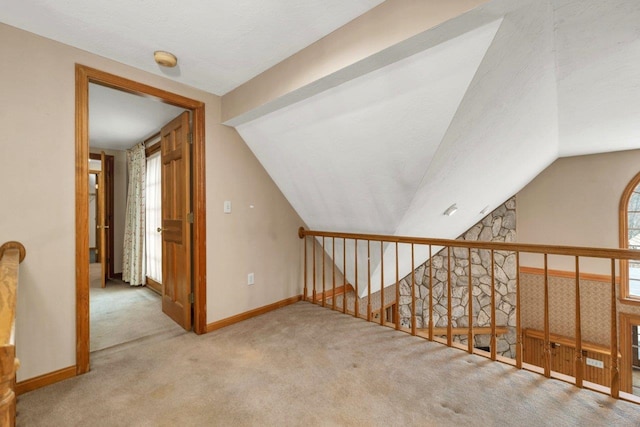 11 Harvest Run, Gilford, NH 03249 - hallway featuring an upstairs landing, carpet flooring, vaulted ceiling, and baseboards