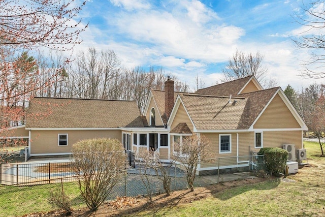 11 Harvest Run, Gilford, NH 03249 - rear view of property featuring a chimney, a shingled roof, a lawn, fence private yard, and a sunroom