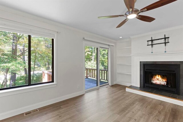 1 Dunvegan Woods Dr, Hampton, NH 03842 - unfurnished living room with wood finished floors, visible vents, baseboards, a tiled fireplace, and built in shelves