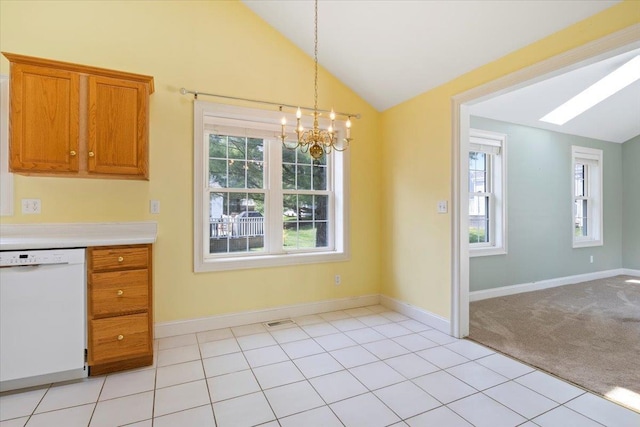 23 Hampton Mdws, Hampton, NH 03842 - kitchen with white dishwasher, lofted ceiling with skylight, brown cabinetry, a chandelier, and light countertops