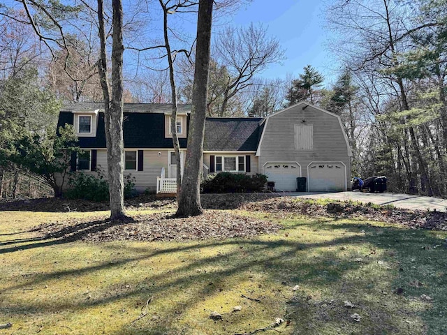 dutch colonial featuring a gambrel roof, a garage, driveway, a shingled roof, and a front yard