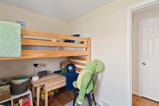 bedroom with visible vents and wood finished floors