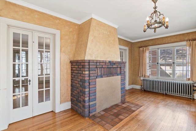 interior space featuring radiator heating unit, a fireplace, a chandelier, and wood-type flooring