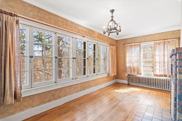 unfurnished sunroom with radiator, a notable chandelier, and french doors