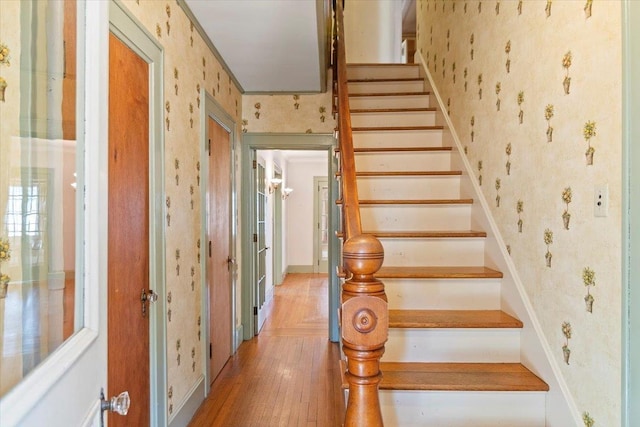 stairs featuring wallpapered walls and wood finished floors