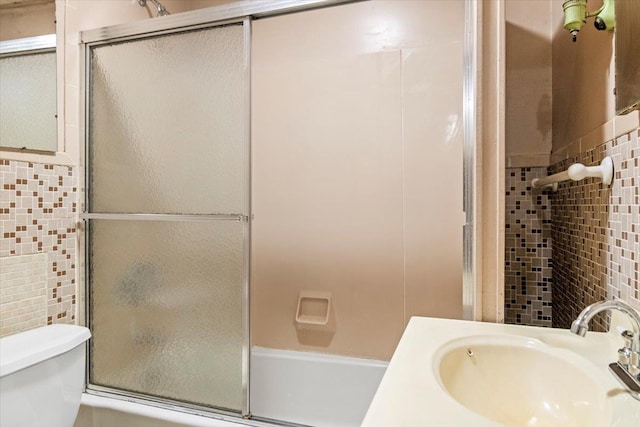 full bathroom with combined bath / shower with glass door, a sink, and toilet