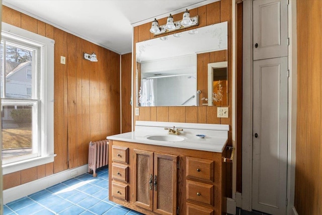 full bath with radiator, tile patterned flooring, wood walls, vanity, and a shower with shower curtain