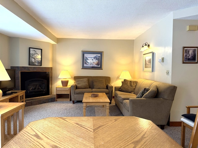 carpeted living room featuring a textured ceiling and a tiled fireplace