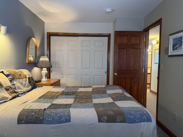carpeted bedroom featuring baseboards, a textured ceiling, and a closet