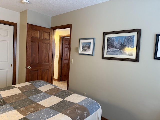 bedroom with a textured ceiling and baseboards