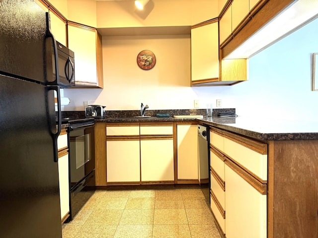kitchen featuring light floors, a sink, and black appliances