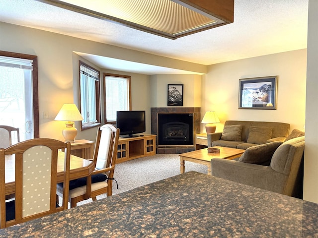 carpeted living room featuring a wealth of natural light and a tiled fireplace