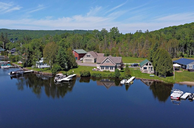 birds eye view of property featuring a forest view and a water view