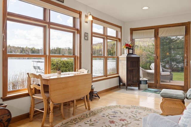 dining room with recessed lighting, baseboards, light wood-style floors, and a water view
