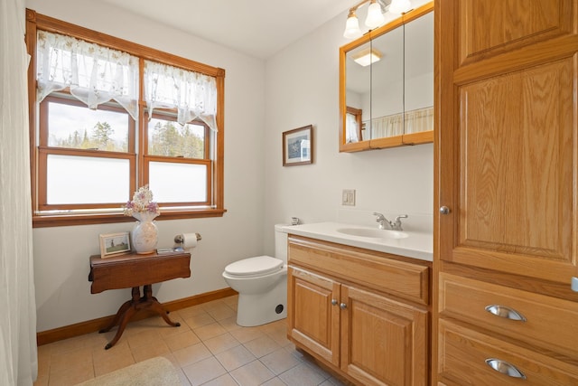 bathroom with baseboards, tile patterned flooring, vanity, and toilet