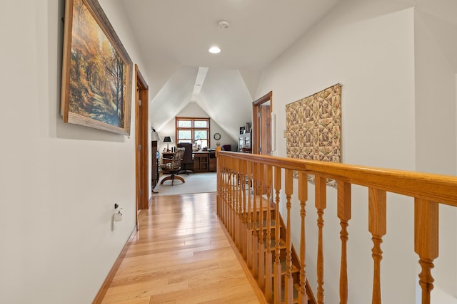 corridor with light wood-style flooring, baseboards, recessed lighting, an upstairs landing, and lofted ceiling