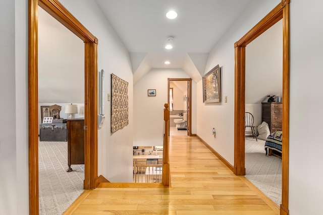 hall featuring baseboards, carpet, recessed lighting, lofted ceiling, and wood finished floors