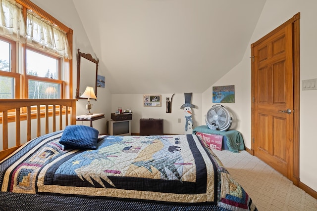 carpeted bedroom with vaulted ceiling and baseboards