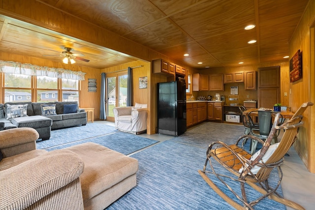 living room with recessed lighting, wood walls, and ceiling fan