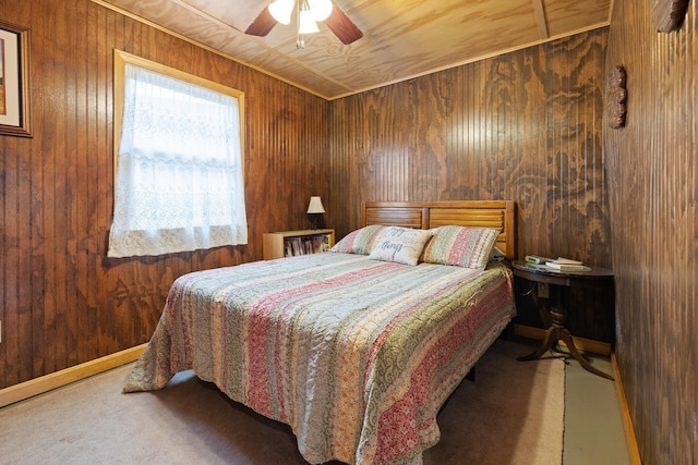 carpeted bedroom with a ceiling fan and wooden walls